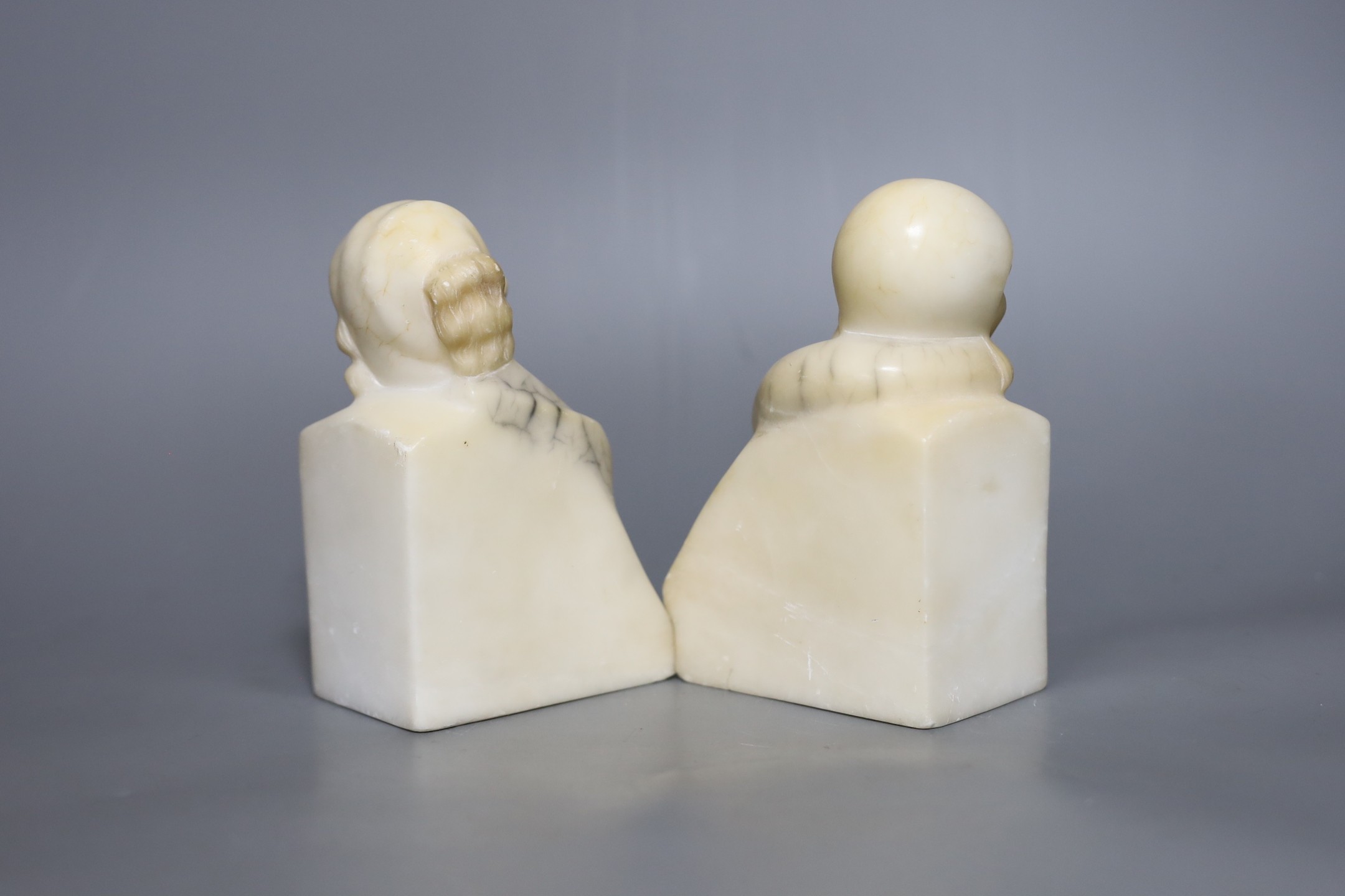 A pair of French Art Deco cream alabaster figural lady bookends, 15 cms high